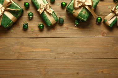 Tahta arka planda topları olan yeşil Noel hediye kutuları.