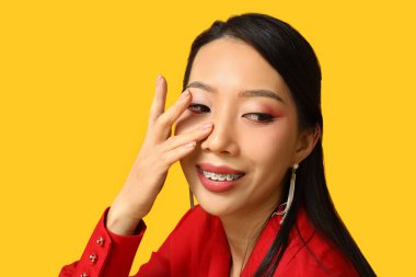 Sarı arka planda güzel bir Asyalı kadın. Çin Yeni Yıl Kutlaması