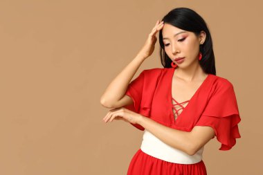 Kahverengi arka planda güzel bir Asyalı kadın. Çin Yeni Yıl Kutlaması