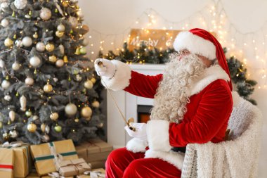 Noel Baba Noel arifesinde evde mektup okuyor.