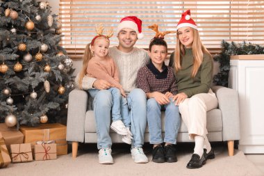 Noel arifesinde aileleri evde oturan mutlu küçük çocuklar.