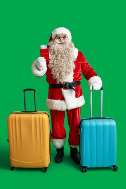 Çantalı Noel Baba, pasaport ve yeşil arka planda bilet. Noel tatili konsepti