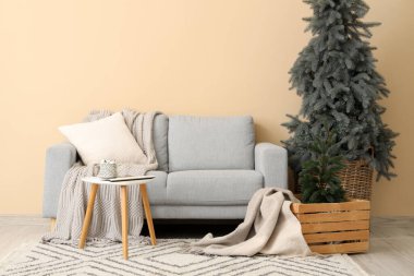 Rahat bir kanepe ve renkli duvarın yanındaki Noel ağaçları.