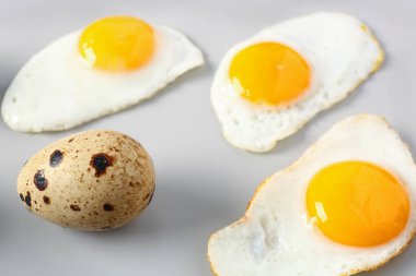 Gri arkaplanda kızarmış bıldırcın yumurtası.