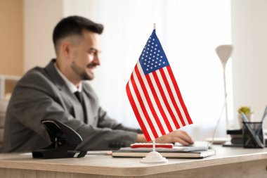 Laptop ve ABD bayrağıyla yakışıklı, genç, mutlu iş adamı.