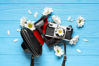 Renkli arka planda klasik fotoğraf makinesi, çanta ve papatya çiçekli kompozisyon