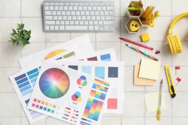 Klavye, kırtasiye ve renk çizelgelerine sahip grafik tasarımcısının çalışma yeri