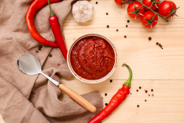 Чаша соуса чили и различные ингредиенты на деревянном фоне