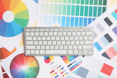 Renk grafikleri üzerinde klavyesi olan grafik tasarımcısının çalışma yeri