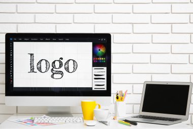 Modern bilgisayar, dizüstü bilgisayar ve çay ile beyaz masa üzerinde grafik tasarımcısının çalışma yeri