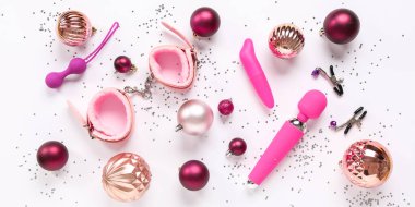 Farklı seks oyuncakları ve beyaz arka planda Noel topları olan kompozisyon