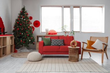 Çin Yeni Yıl kutlamaları için dekore edilmiş oturma odasının içinde kırmızı kanepe ve Noel ağacı var.