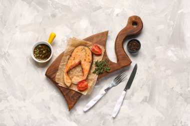 Gri arka planda lezzetli somon bifteği tahtası