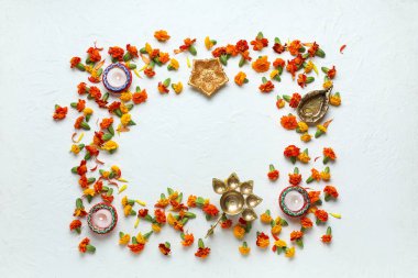 Didiya lambalarından yapılmış çerçeve, yanan mumlar ve beyaz arka planda kadife çiçekleri. Divaly kutlaması