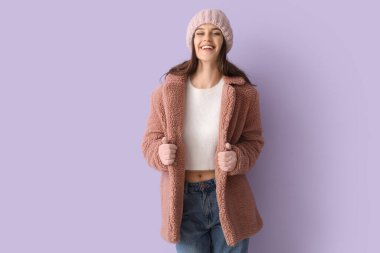 Leylak arkaplanda oyuncak ceketli genç bir kadın.