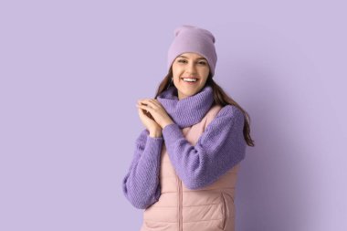 Leylak arka planında, kışlık elbiseli genç bir kadın.