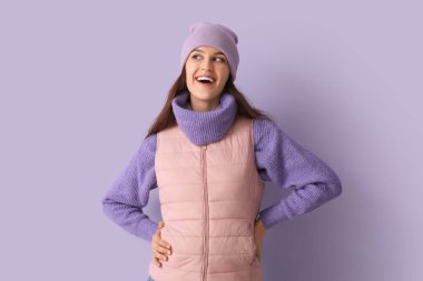 Leylak arka planında, kışlık elbiseli genç bir kadın.