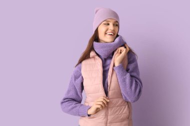 Leylak arka planında, kışlık elbiseli genç bir kadın.