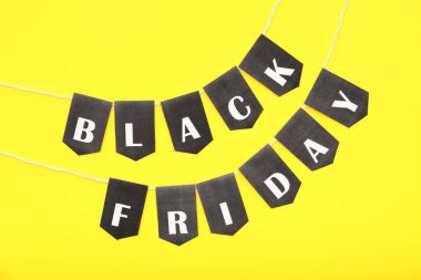 Sarı arkaplanda Kara Cuma yazılı halat ve bayraklar