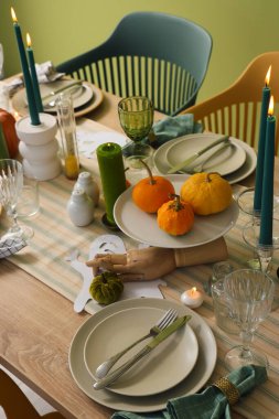 Cadılar Bayramı partisi için yanan mumlar ve balkabaklarıyla şenlik masası, yakın plan.