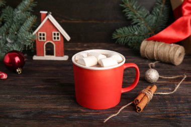 Bir fincan lezzetli Noel kakaosu, marşmelov ve ahşap arka planda tarçın.