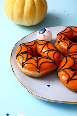 Mavi arka planda Cadılar Bayramı için bir tabak lezzetli çörek.