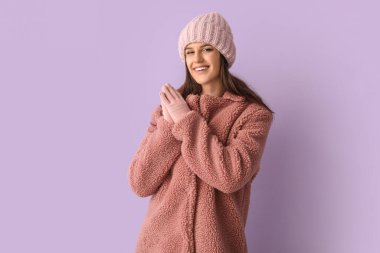 Leylak arkaplanda oyuncak ceketli genç bir kadın.