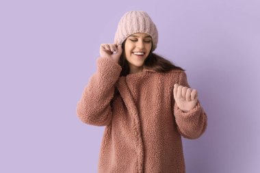 Leylak arkaplanda oyuncak ceketli genç bir kadın.