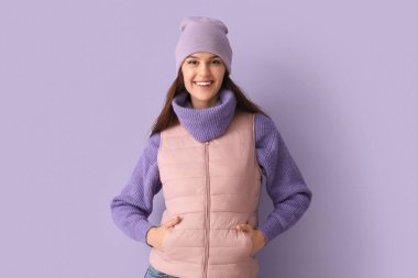 Leylak arka planında, kışlık elbiseli genç bir kadın.