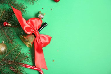 Köknar dalları ve yeşil arka planda topları olan Noel çanı