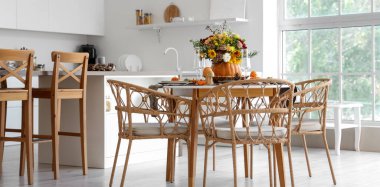 Mutfaktaki yemek masasında sonbahar çiçekli balkabağı.