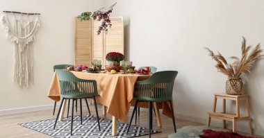 Güzel bir sonbahar masası. Çiçekler ve balkabakları hafif yemek odasında.