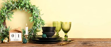 Noel dekorlu temiz tabaklar ve sarı arka planda takvim. Tasarım için pankart