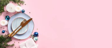 Noel yemeği için çok güzel bir masa, pembe arka planda süslemeleri ve metin için yeri var.