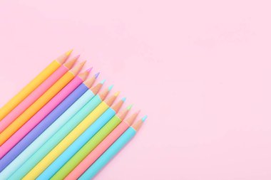 Pembe arka planda bir sürü renkli kalem