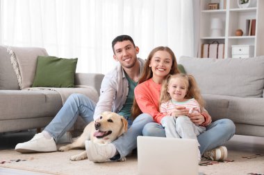 Labrador köpeği ve dizüstü bilgisayarı olan mutlu bir aile.