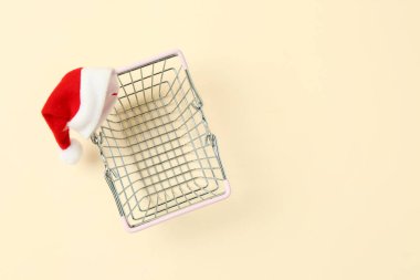 Arka planda Noel Baba şapkası olan alışveriş sepeti.