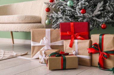 Oturma odasında hediyelerle süslenmiş Noel ağacı.