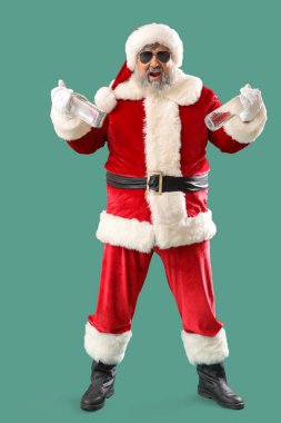 Yeşil arka planda votka şişeleri olan kötü Noel Baba.