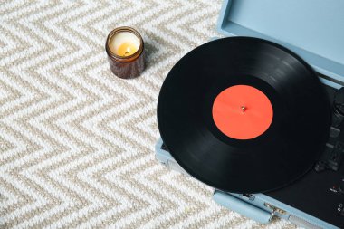 Klasik müzik çalar ve hafif halıda yanan mum.