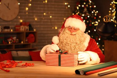 Noel Baba evde Noel hediyesi yapıyor.