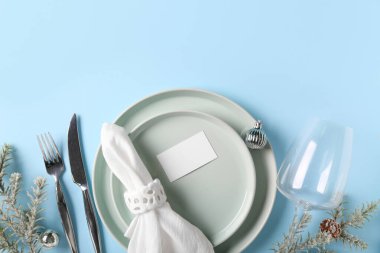 Köknar dalları, Noel topları ve mavi arka planda çam kozalakları olan güzel bir masa.