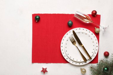 Beyaz arka planda Noel topları ve köknar dallarıyla güzel bir masa.