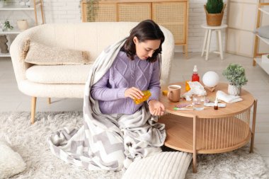 Hasta genç kadın evde hap alıyor.