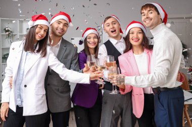 Yeni yılı ofis partisinde şampanya ve konfetiyle kutlayan genç meslektaşlarım.