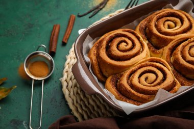 Yeşil arka planda lezzetli tarçınlı börek pişirme