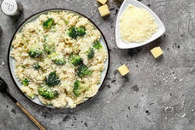 Gri zemin üzerinde brokoli olan lezzetli bir makarna tabağı.