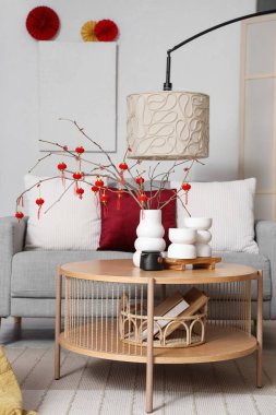 Ağaç dalları olan vazolar, Çin fenerleri ve oturma odasındaki masada çaydanlık. Çin Yeni Yıl Kutlaması