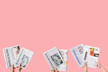 Pembe arka planda gazeteleri olan kadınlar