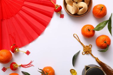 Beyaz arka planda kağıt vantilatör, mandalina ve Çin sembollerinden yapılmış çerçeve. Yeni yıl kutlaması